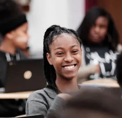 School Sponsorship a student sitting smiling in class